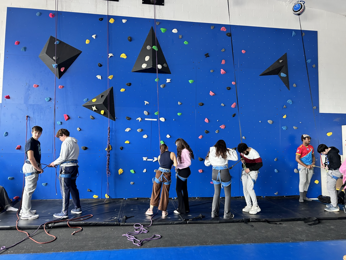 Adeline de la Paz (10) assists her fellow classmates climb the rock wall in the PE class, Adventure Pursuits. She found the part of engaging your body the hardest part of rock climbing. "It's rewarding to be able to help other learn to climb because I love it so much," de la Paz said.